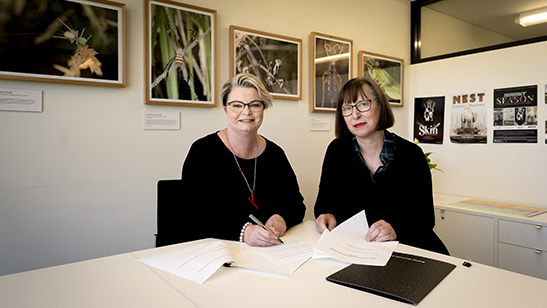 Tracy Puklowki and Janet Carding signing the memorandum of understanding